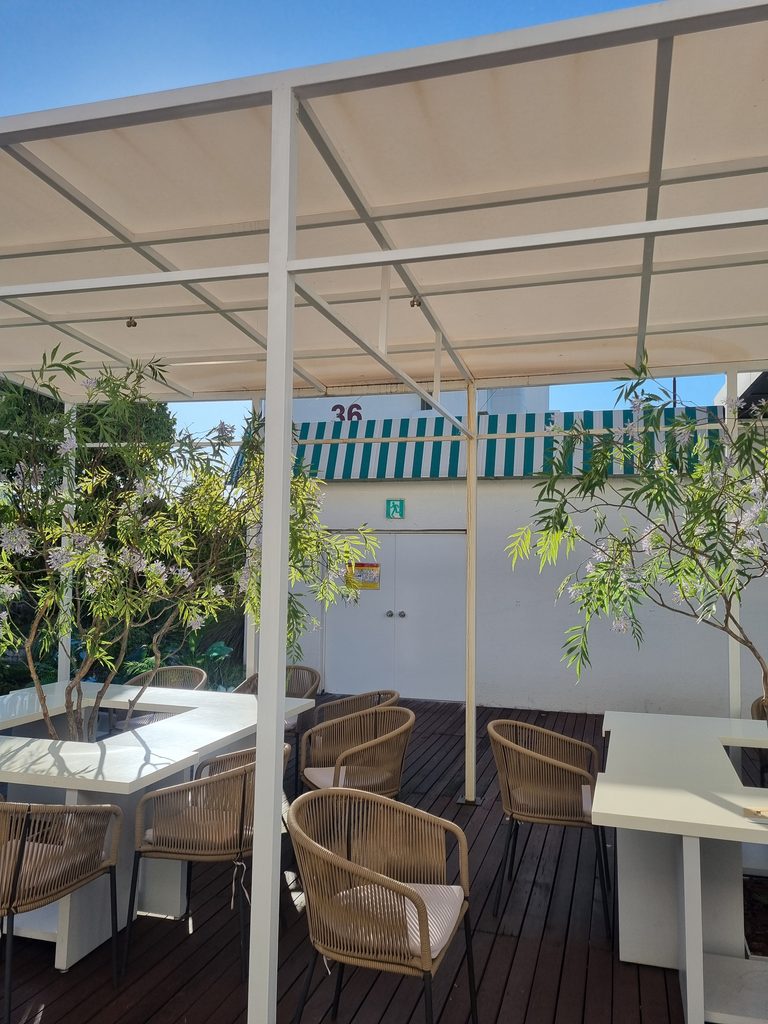 Outdoor patio with tables and chairs beside Maison Southcape Cafe at Galleria Department Store Seoul